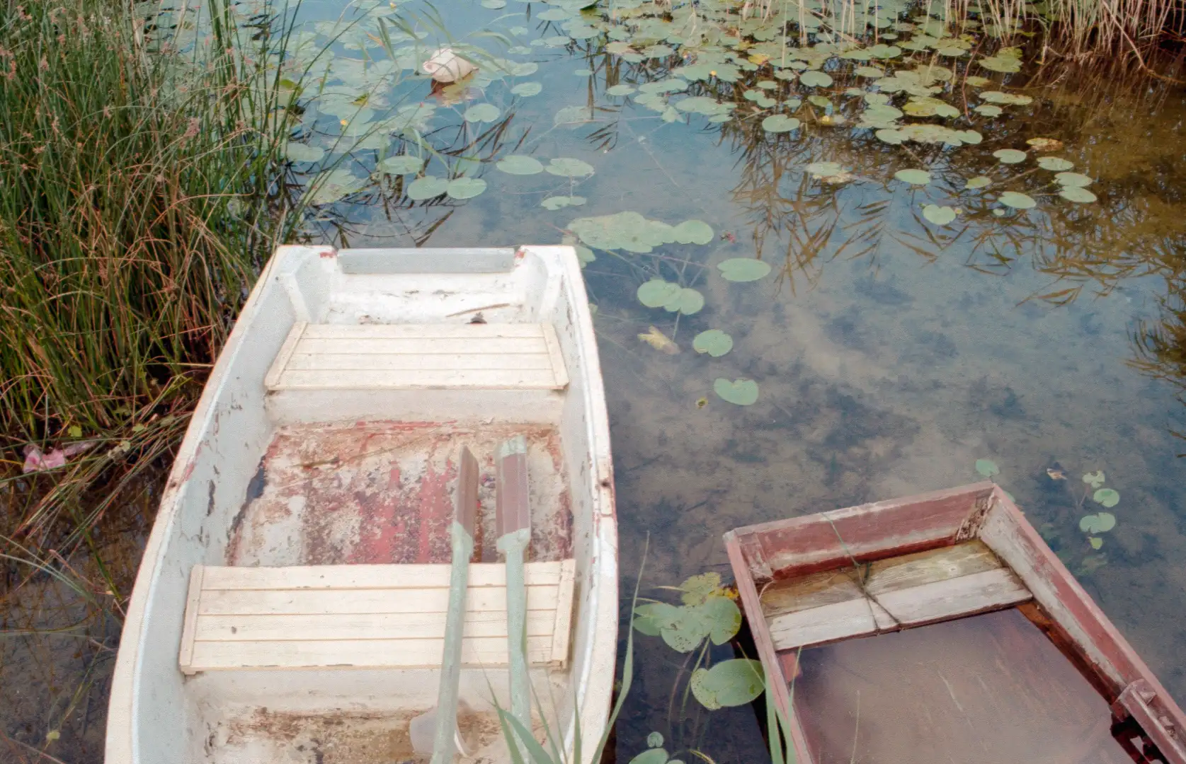 Picture of boats sitting still in a shallow lake. Created and photographed by Hiroku