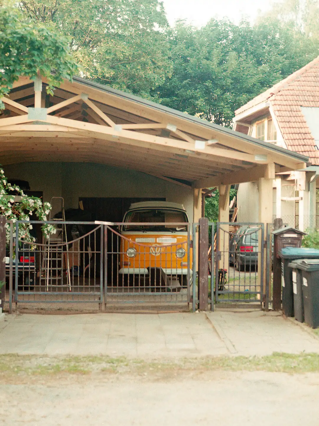 An old style vehicle in an orange color parked in a garage. Created and photographed by Hiroku