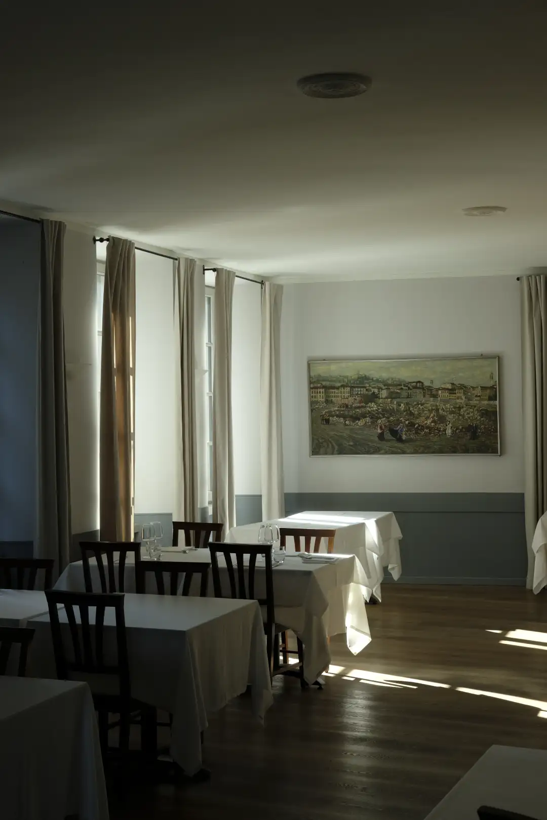 A photo of an old empty restaurant being lit up by a beam of sunlight. Created and photographed by Hiroku