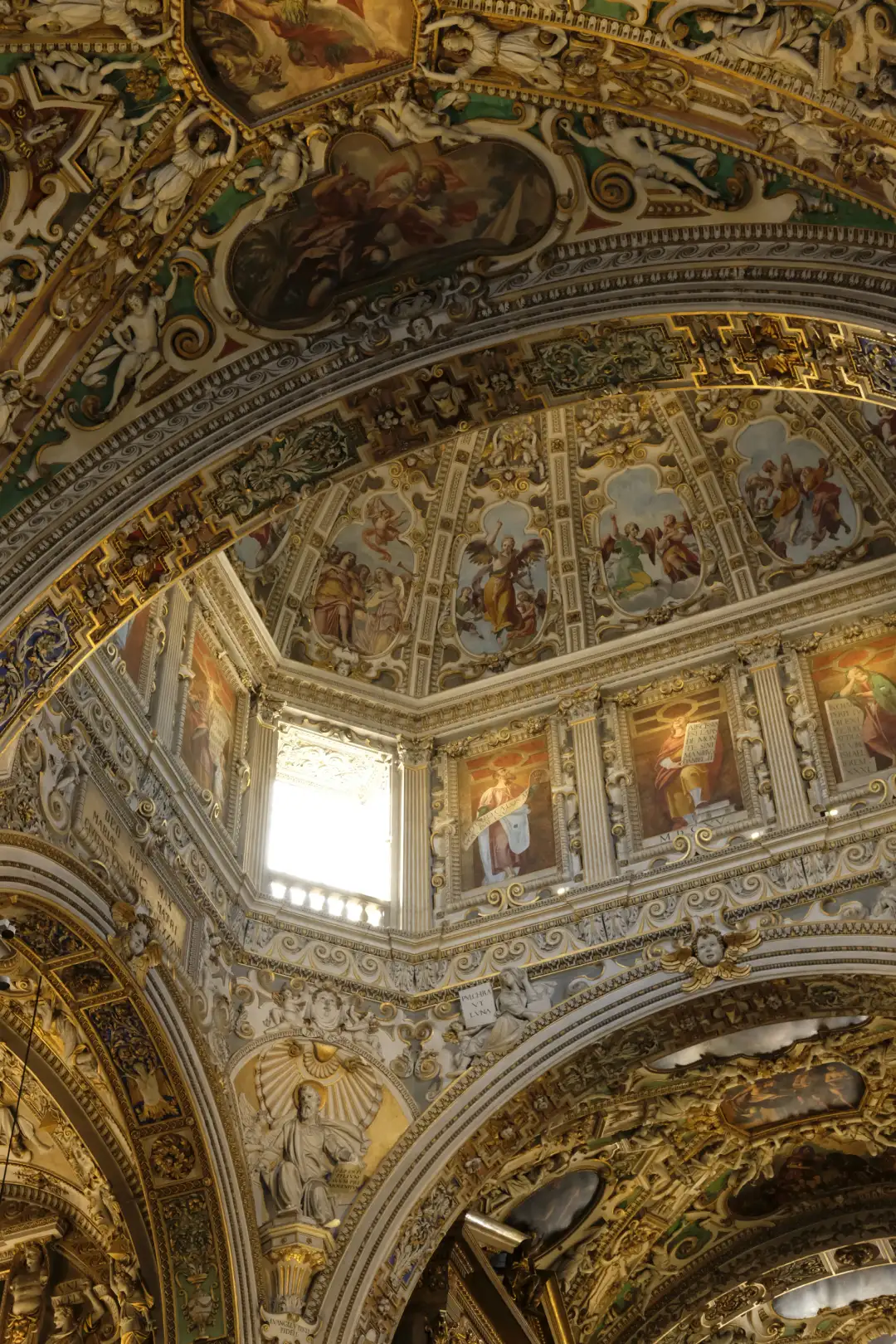 The ceiling of an old church with a small window with sunlight shinning through it. Created and photographed by Hiroku