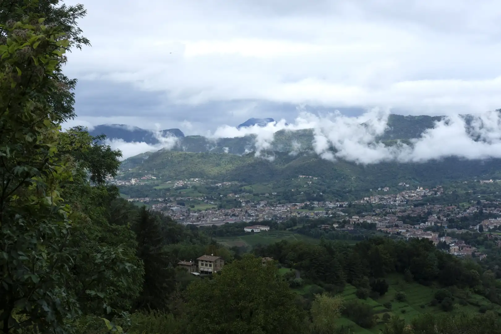 A mountainous landscape with a small village set inbetween green big mountains. Created and photographed by Hiroku