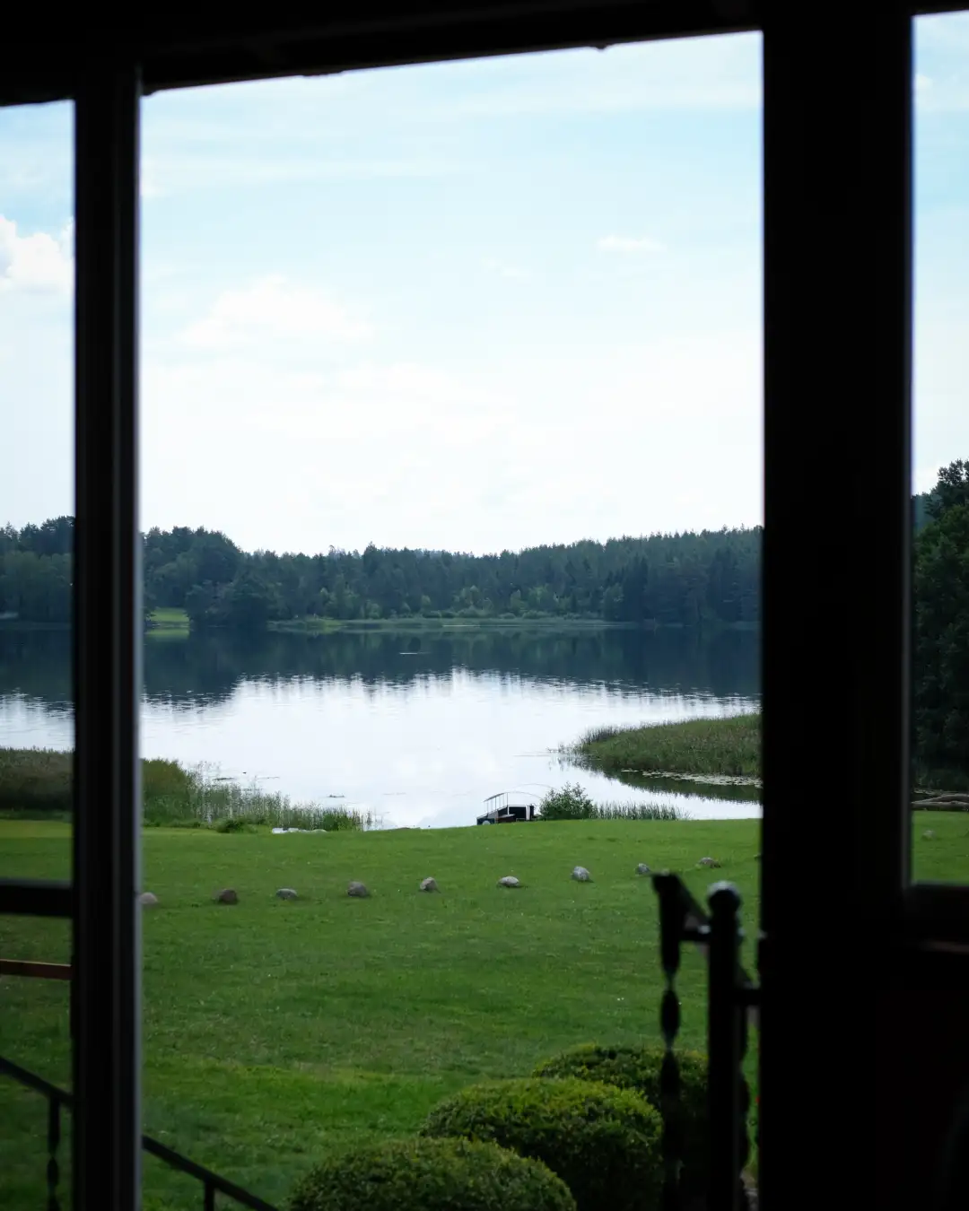In image of a lake sillouted by a dark wooden archway. Created and photographed by Hiroku