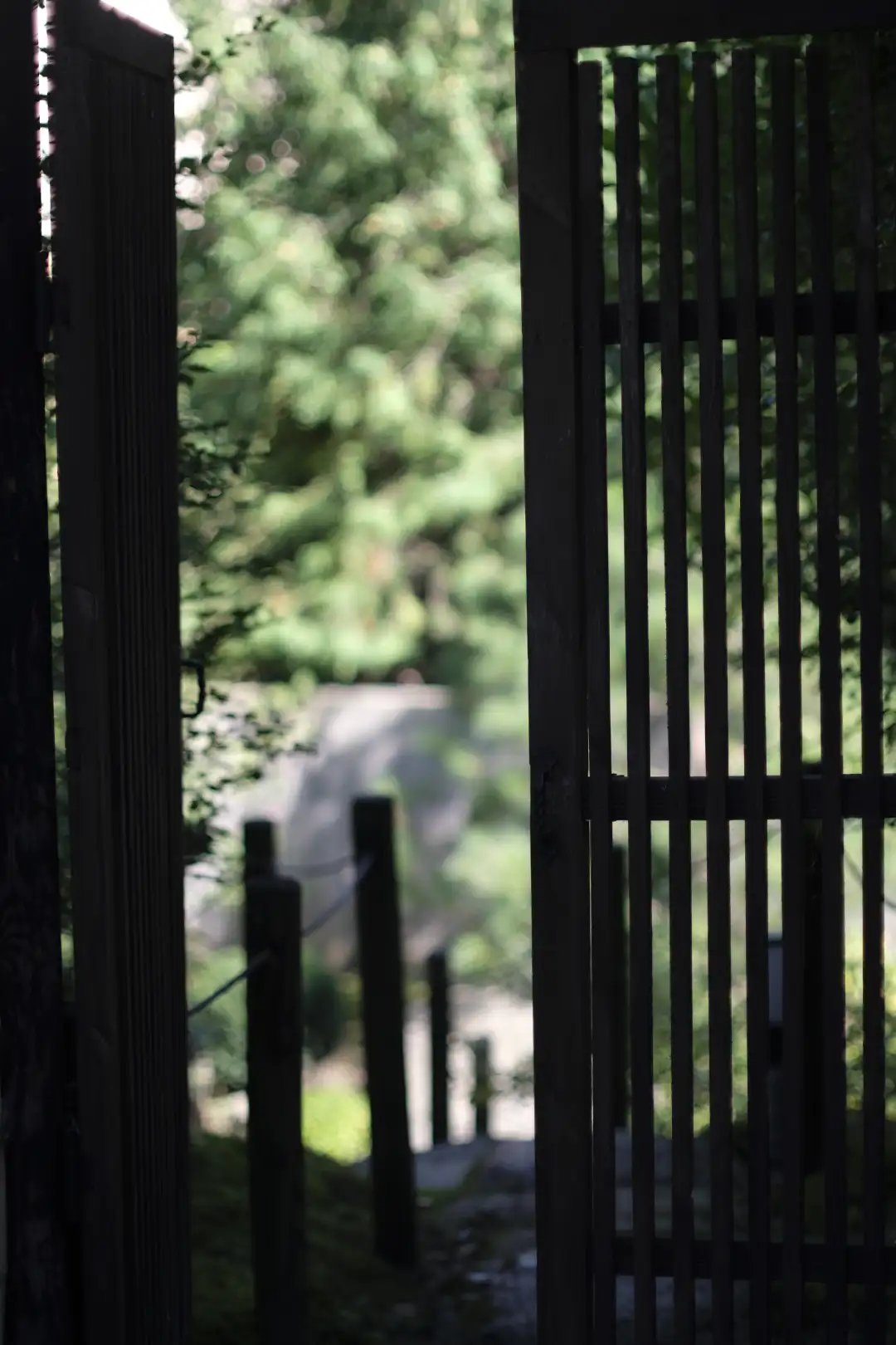 A wooden japanese gate with an out of focus nature background. Created and photographed by Hiroku