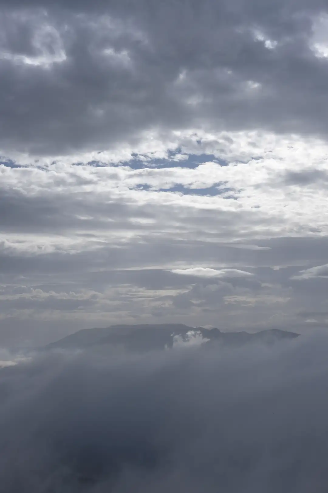 A lonely mountain that's peeking through the clouds. Created and photographed by Hiroku