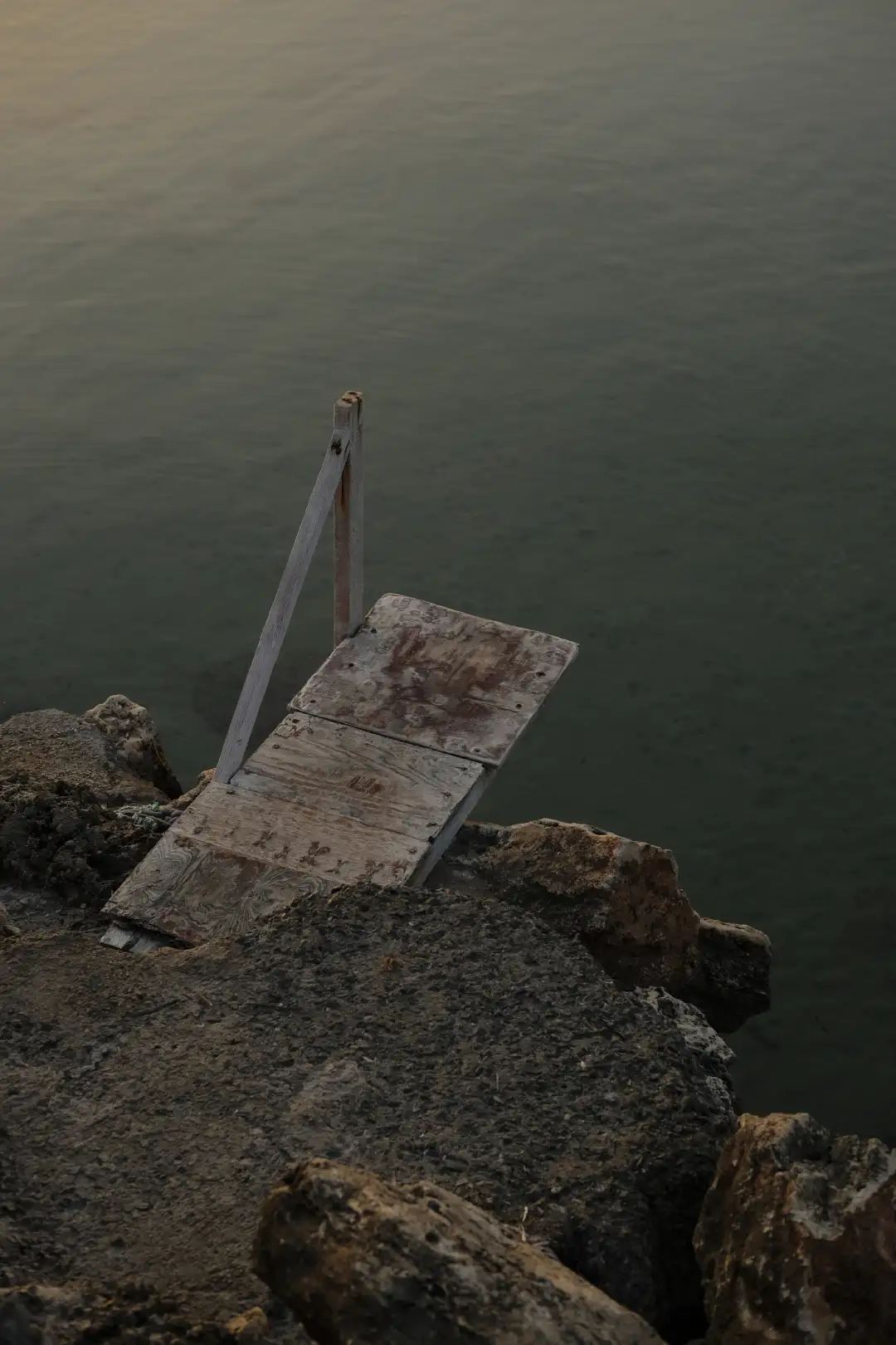 A diving board that's stationed above a calm sea. Created and photographed by Hiroku